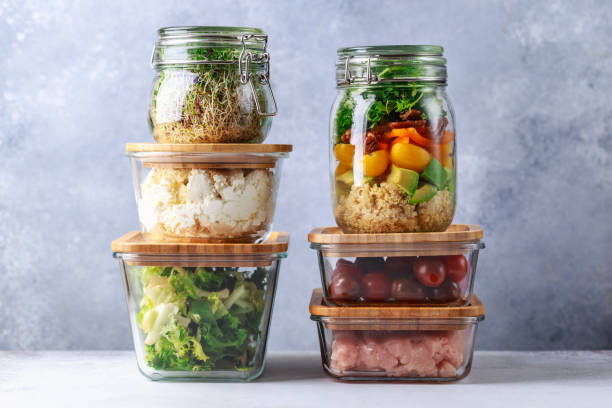 glazen dozen en blikjes met verse voedsel koelkast opslag concept decanteren - container stockfoto's en -beelden