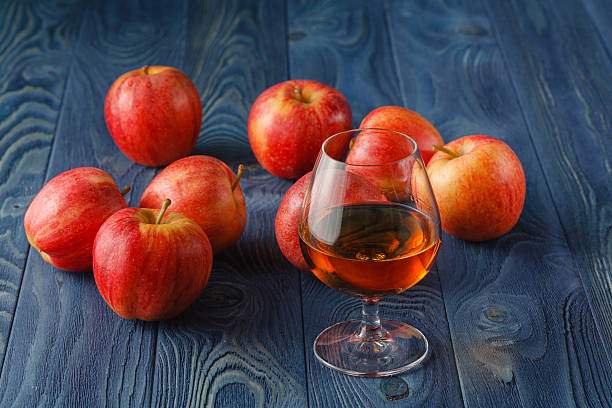 glass of Calvados Brandy and red apples glass of Calvados Brandy and red apples calvados stock pictures, royalty-free photos & images