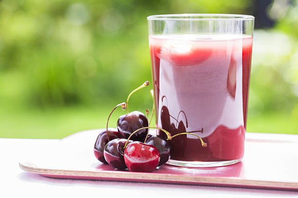 Glass of Cold cherry  juice in garden red smoothie berries tray sour taste stock pictures, royalty-free photos & images