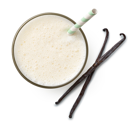 Glass of fresh vanilla milkshake or smoothie isolated on white background, top view