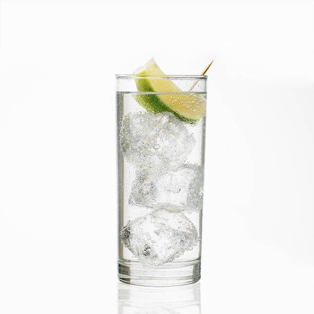 Glass of gin and tonic with ice and lime stock photo