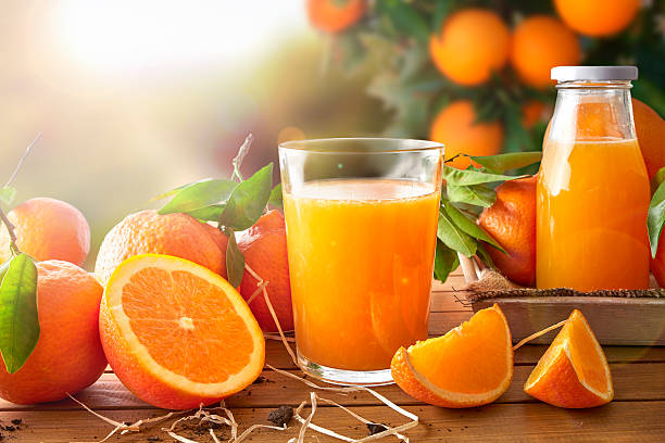 Glass of orange juice on a wooden in field stock photo
