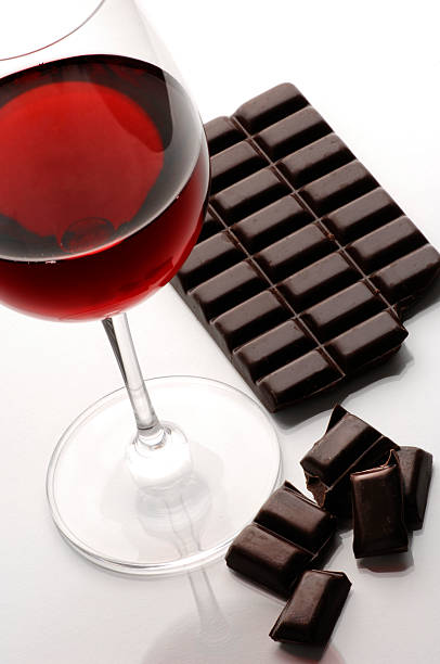 Glass of red wine and broken block of dark chocolate stock photo