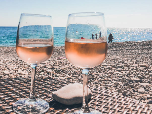 Glass of rose wine on a beach in French Riviera Cote d'Azur French Riviera is situated in the southern eastern part of the mediterranean coast of France and it is famous for its exclusive beaches and its beautiful sea rose wine stock pictures, royalty-free photos & images