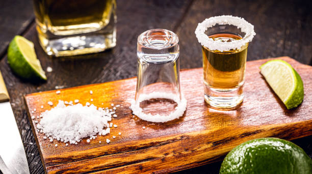 glass of tequila with ingredients around, mexican drink preparation stock photo