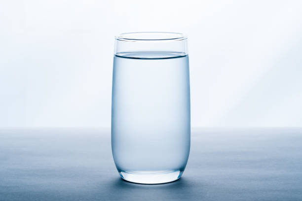 glas wasser auf weißem hintergrund. - trinkglas stock-fotos und bilder