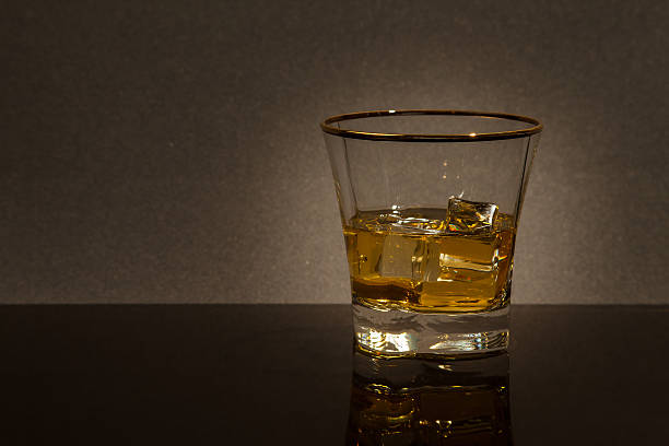 glass of whiskey on a glass table stock photo