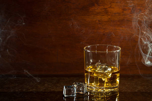 glass of whiskey on glass table stock photo