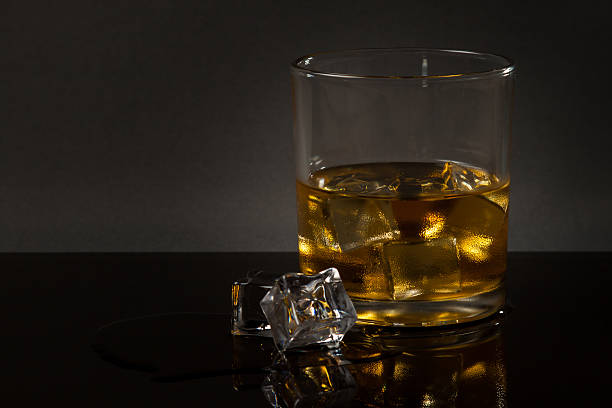 glass of whiskey on glass table stock photo
