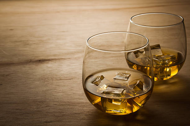 glass of whiskey on wooden table stock photo