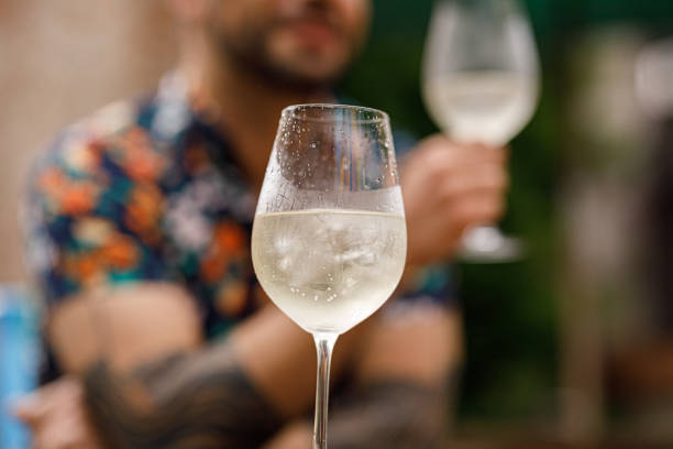 Glass of white wine in front of a man stock photo