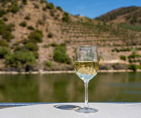Glass of white wine on a cruise boat on Douro river in Portugal