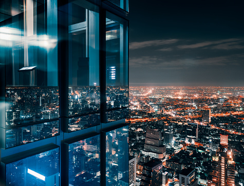 Glass window with glowing crowded city