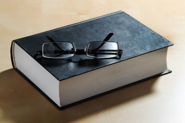 Glasses and a thick book in hardcover. stock photo