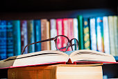 istock glasses and book on background bookcase 521527756