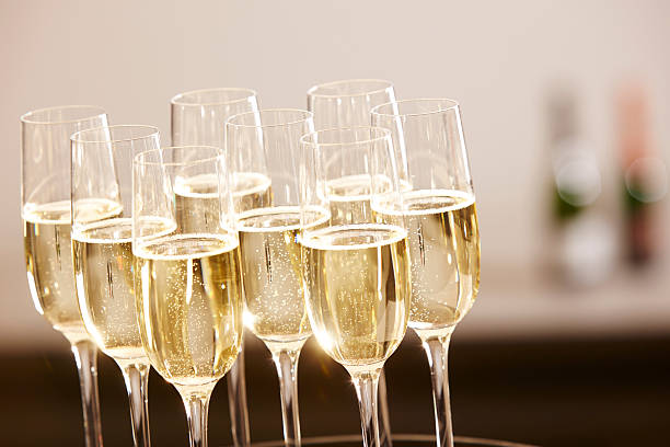 Glasses full of champagne on a tray stock photo