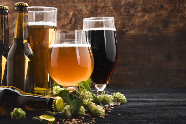 Glasses of beer with green hops and wheat beer and ingredients artisanal food and drink photos stock pictures, royalty-free photos & images