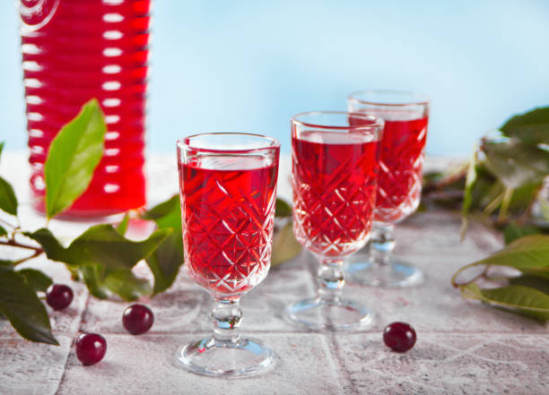 glasses of cherry brandy liqueur with ripe berries stock photo
