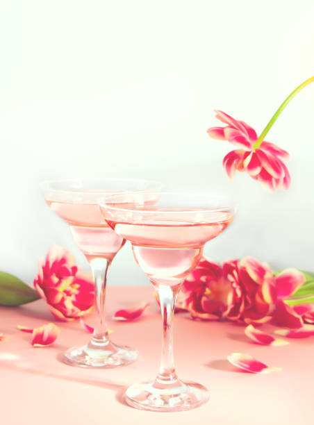 Glasses of pink cocktails with flowers and petals. Birthday party or Valentines day romantic couple concept. stock photo