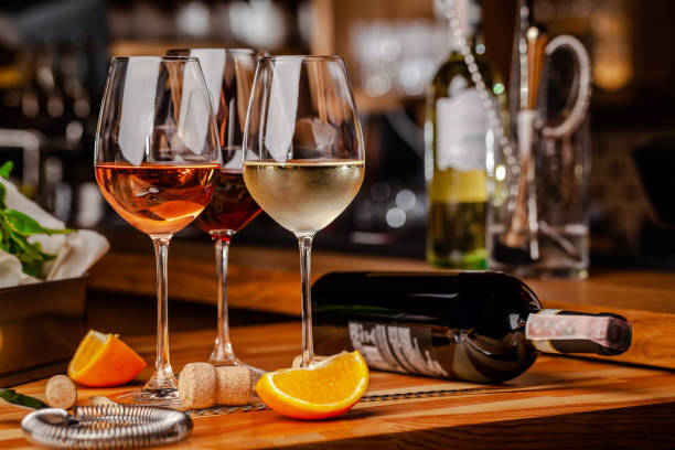 Glasses of white, rose and red wine are on the table, a bottle and corks are nearby. Glasses are on the table in the bar in the restaurant. Background image. copy space stock photo