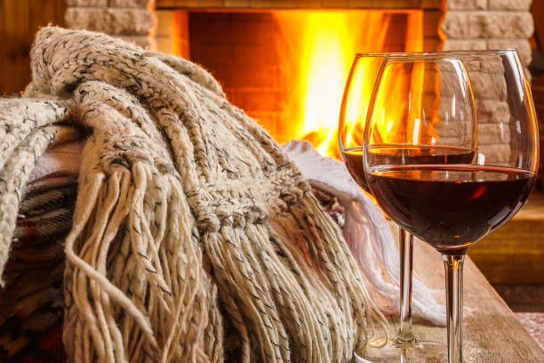 Glasses of wine against cozy fireplace background, winter vacation. stock photo