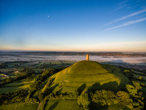 Glastonbury Tor at sunrise Glastonbury Tor in Somerset at sunrise outcrop stock pictures, royalty-free photos & images