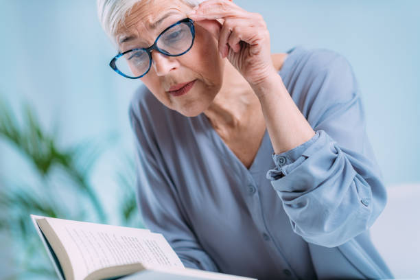 Glaucoma. Senior Woman a Reading Book, Having Ocular Tension. stock photo