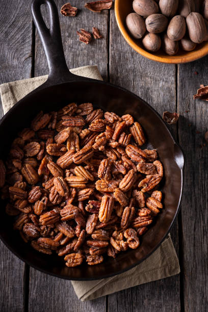 Glazed Pecans Fresh Glazed Pecans in a Cast Iron Skillet pecan stock pictures, royalty-free photos & images