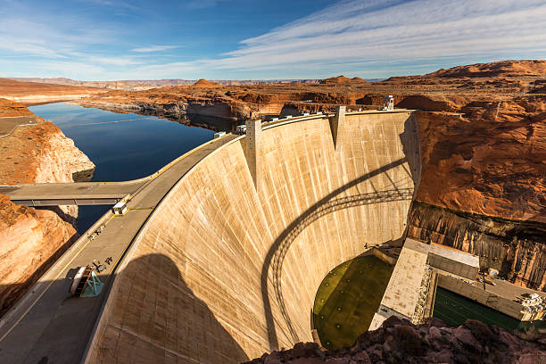 Glen Canyon Dam at Page, Arizona Glen Canyon Dam is a concrete arch dam on the Colorado River in northern Arizona in the United States, near the town of Page. The dam was built to provide hydroelectricity and flow regulation from the upper Colorado River Basin to the lower. Its reservoir is called Lake Powell, and is the second-largest artificial lake in the country. coconino county stock pictures, royalty-free photos & images