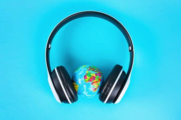 Globe in white wireless headphones on blue background. Concept for an international day of music. stock photo