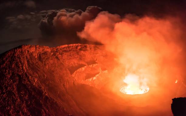 Glowing clouds of smoke emitted from lava lake inside active Nyiragongo volcano lit by moonlight Wide angle shot of lava lake and smoke in Nyiragongo volcano volcanic crater stock pictures, royalty-free photos & images