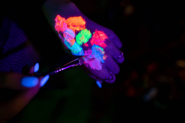 Glowing Colors Close-up shot of hands of the body paint artist. paint neon color neon light ultraviolet light stock pictures, royalty-free photos & images