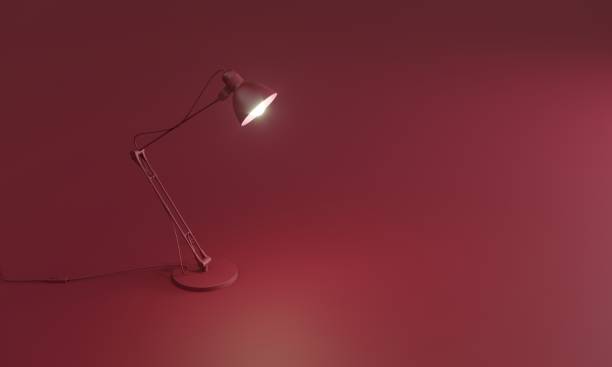 Glowing desk lamp on red floor stock photo