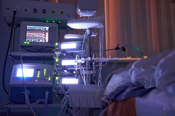 Glowing monitors in intensive care department. Nigth shift at icu, patient in critical state. stock photo