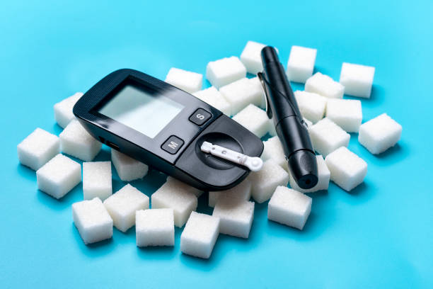 glucometer, sugar cubes on blue background High blood sugar and diabetes concept Top view Flat lay 14 November - World Diabetes Day glucometer, sugar cubes on blue background High blood sugar and diabetes concept Top view Flat lay 14 November - World Diabetes Day. diabetic foot stock pictures, royalty-free photos & images