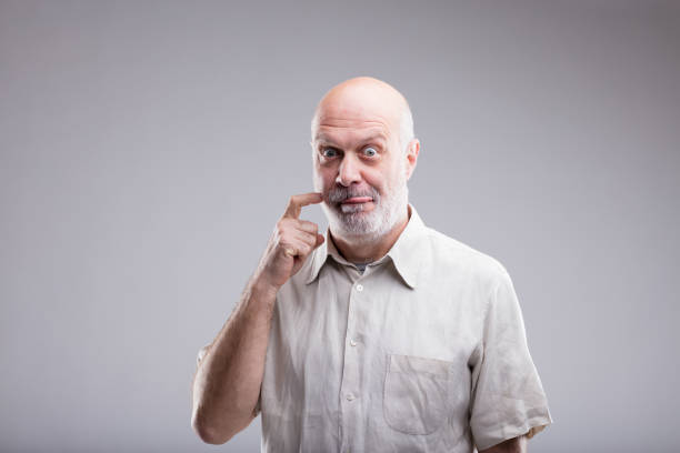 gluttonous bald old man says yummy bald old man making a gesture that means that ffood is delicious and he wants to eat it now emotional series stock pictures, royalty-free photos & images