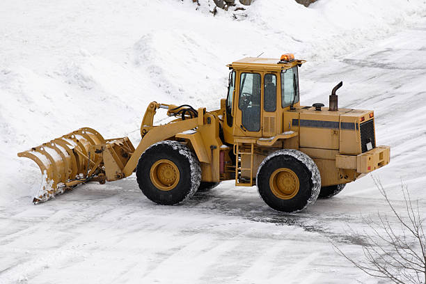 Go Away Snow! huge plow plowing parking lot after storm stock photo