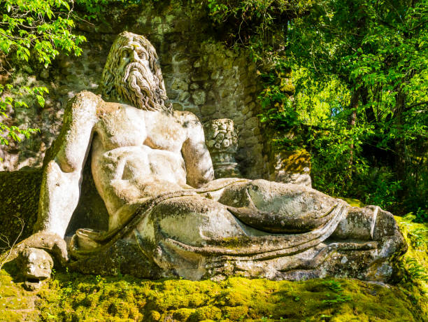 God Neptune at famous Park of the Monsters, also named Sacred Grove, Bomarzo Gardens, province of Viterbo, Lazio, Italy Colossal sculpture of god Neptune at famous Park of the Monsters, also named Sacred Grove, Bomarzo Gardens, province of Viterbo, Lazio, Italy neptune roman god stock pictures, royalty-free photos & images
