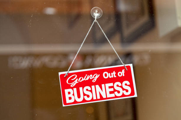 Going out of business - Closed sign Red sign hanging at the glass door of a shop saying: "Going out of business". bankruptcy stock pictures, royalty-free photos & images