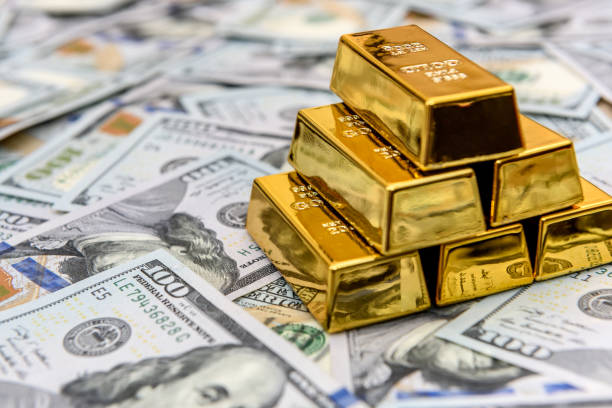 Gold bullion on american dollar banknotes close up stock photo