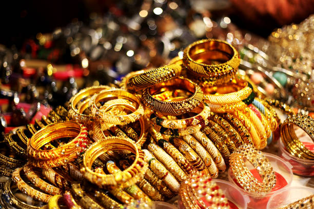 Gold colored bracelets Bracelets and bangles in a row in street market. indian jewelry stock pictures, royalty-free photos & images