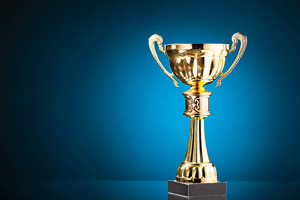 gold cup trophy on blue background stock photo