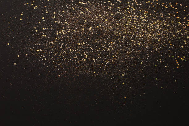 Gold glitter on black background. Holiday abstract texture stock photo