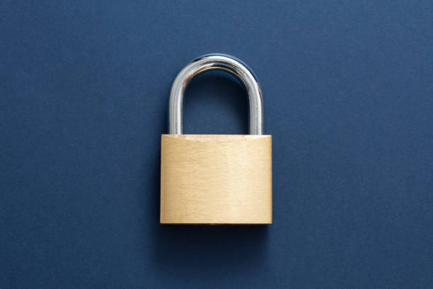 Gold Lockpad Padlock Locked golden padlock on the blue background. padlock stock pictures, royalty-free photos & images