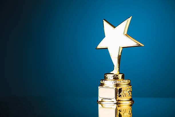 gold star trophy against blue background shiny gold star trophy against blue background with copy-space trophy award stock pictures, royalty-free photos & images