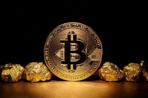 Golden Bitcoin Coin And Mound Of Gold On Black Background Stock Photo
