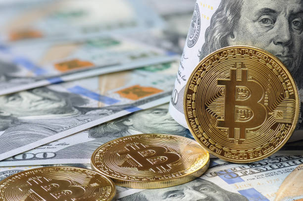 monete d'oro bitcoin (btc) sullo sfondo delle banconote banconote da 100 dollari con il presidente benjamin franklin. - bitcoin foto e immagini stock