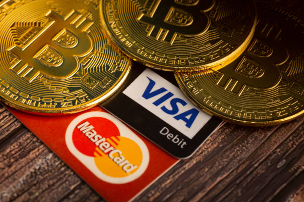 goldener bitcoin mit visa- und mastercard-logo-token auf holzhintergrund. digitale währung. kryptowährung. bitcoin-geldbörse - bitcoin stock-fotos und bilder