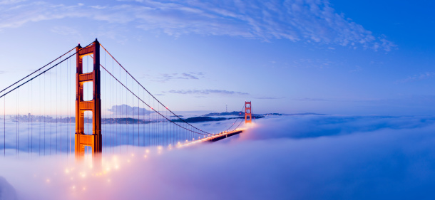 The Golden Gate bridge in San Francisco surrounded by fog at twilight, USA.