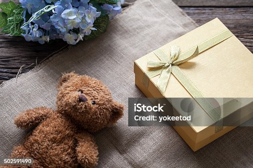 istock Golden gift box and teddy bear 502591490
